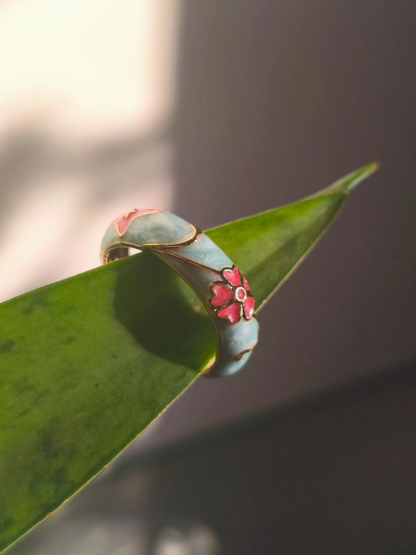 Gold-tone open enamel ring, sky-blue band with pink flower centerpiece and scalloped edges