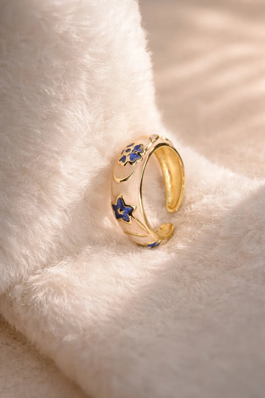 Gold-tone ring with blue star and flower enamel accents