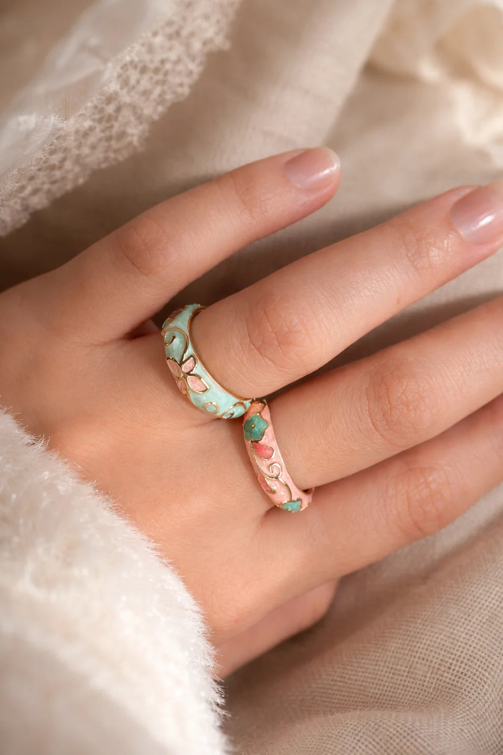 Mint enamel blossom ring on hand with pink flowers and gold-tone band