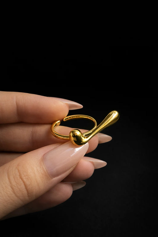 Gold-tone abstract ring with curved band and rounded top detail