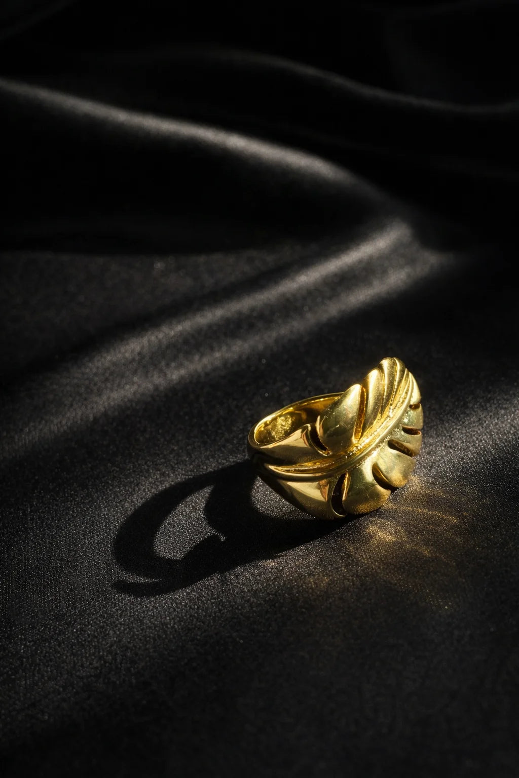 Gold-tone banana leaf statement ring with curved leaf design, close-up