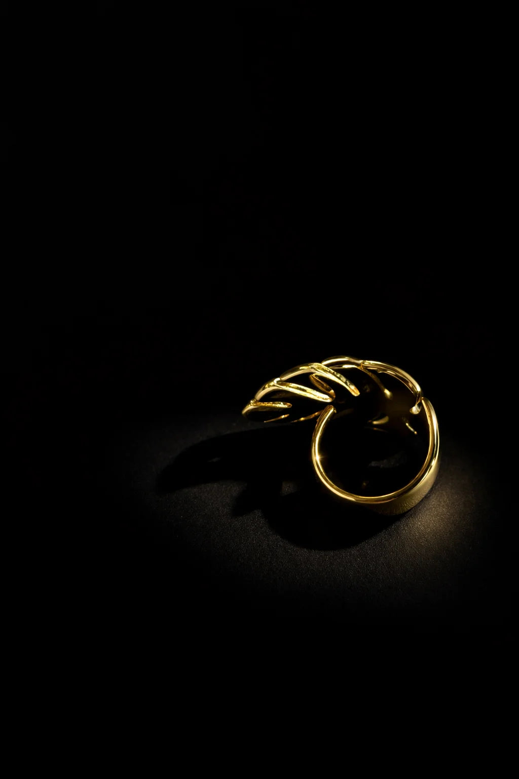 Gold-tone banana leaf ring with open leaf band, side view