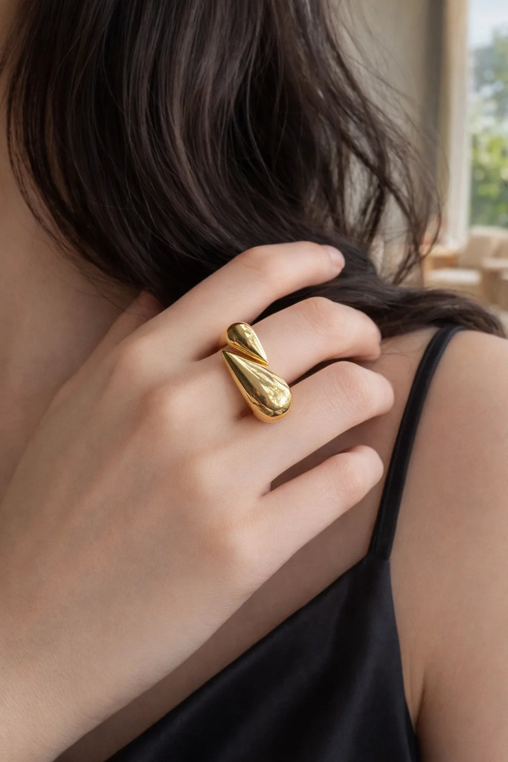 Gold-tone hug ring with teardrop form on finger