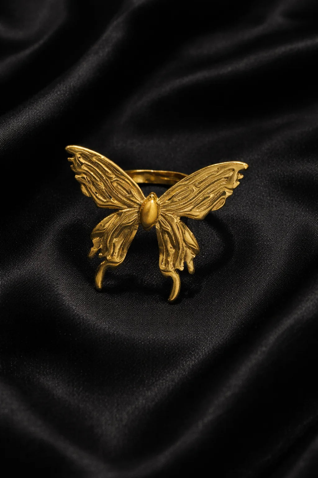 Gold-tone butterfly ring with openwork wings and a central round stone