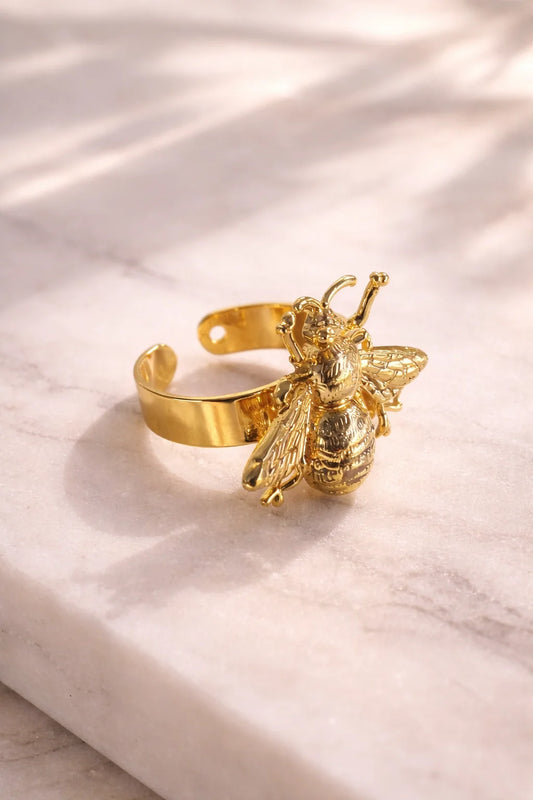 Gold beetle charm ring with open band and raised insect detail