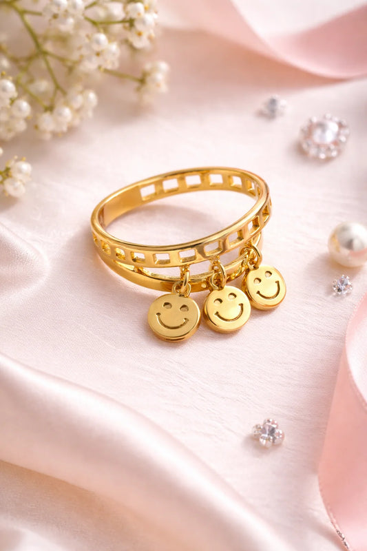 Gold-plated ring set with smiley charm drops and smiley faces on squared band