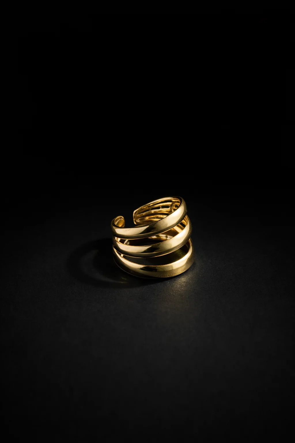 Gold three-layer ring with stacked curved bands, polished finish