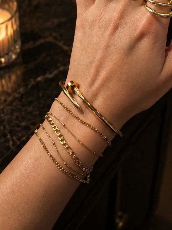 Stack bracelets on wrist with fine gold chain links and several slim bands