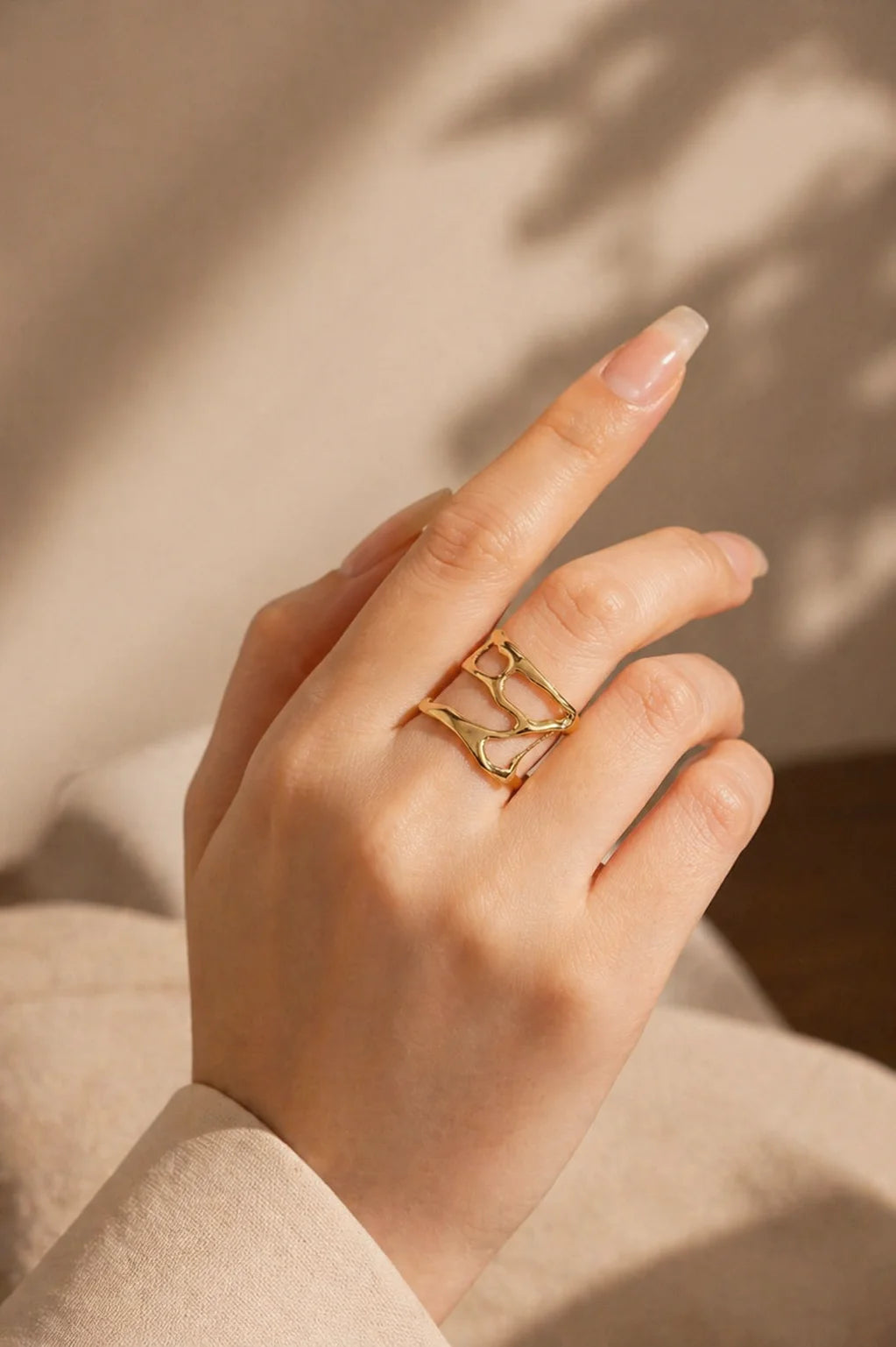 Gold open statement ring with three curved bands on finger