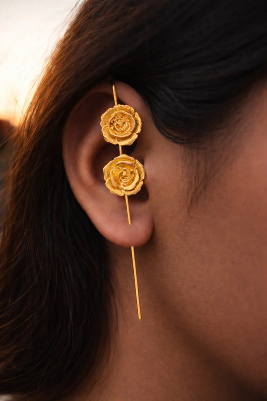 Gold-tone rose ear cuff with three stacked rose blooms on a drop hook