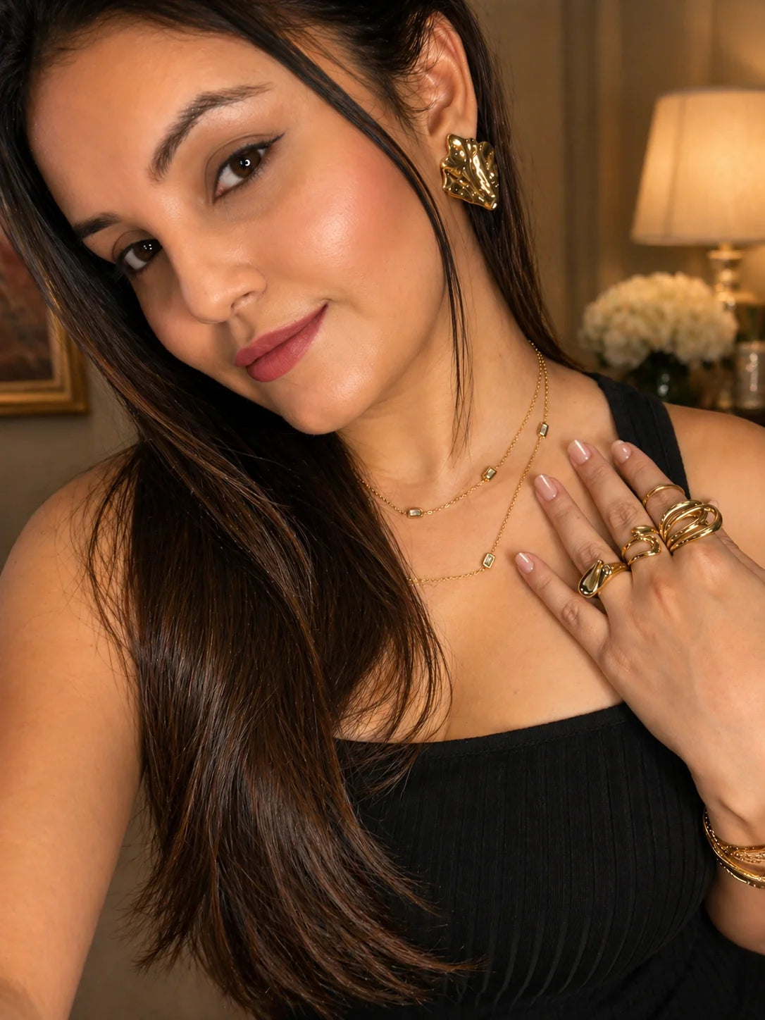 Layered gold chain necklace with square charm pendants worn at collarbone