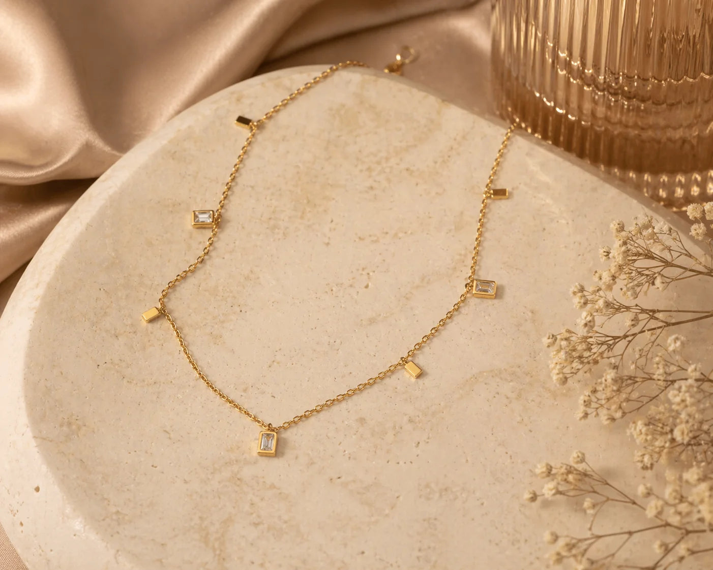 Gold square charm necklace with small square charms spaced along a fine chain
