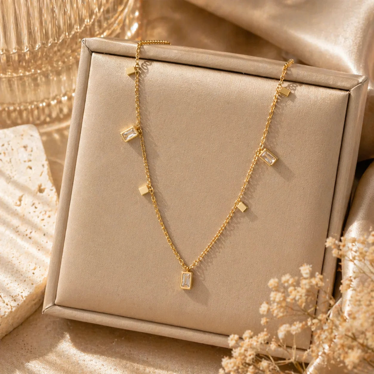 Gold square charm necklace on jewelry box, linked chain with square charms