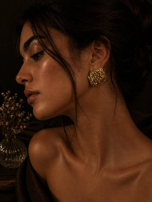Gold-plated stack stud earrings with textured stacked bars, worn on ear