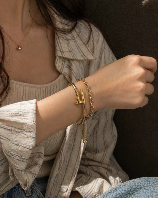 Stacked & Unbothered bracelet combo: gold chain and cuff bracelets on wrist
