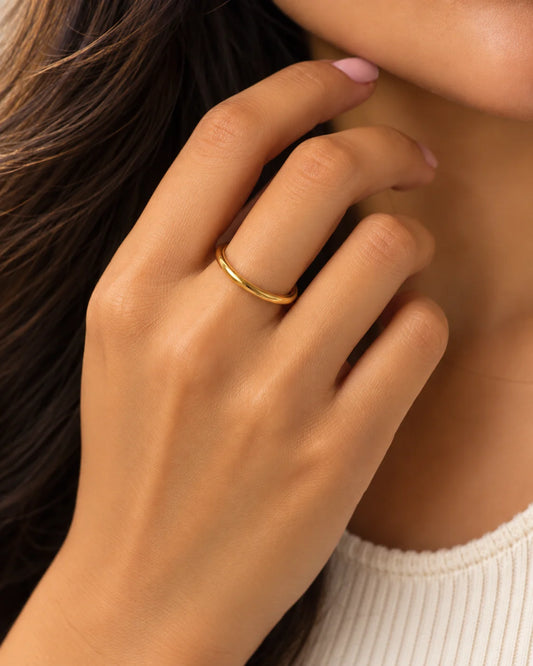 Gold-plated stackable ring on finger, slim smooth band