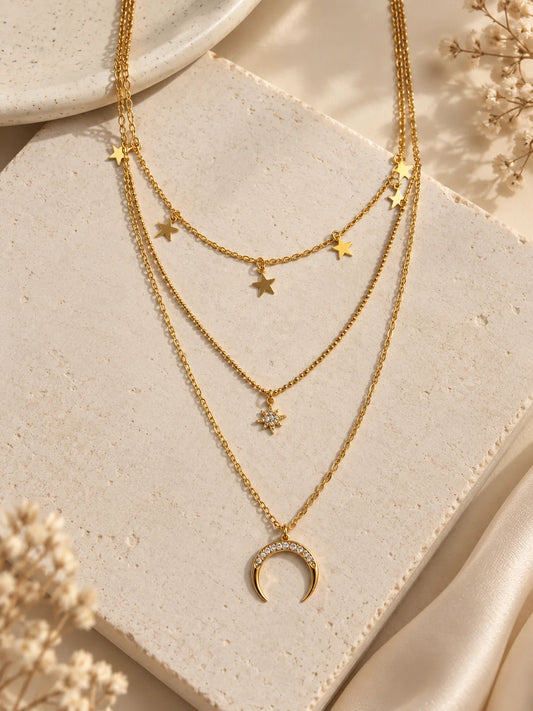 Gold triple-layer necklace with star charms across three chains and crescent moon pendant