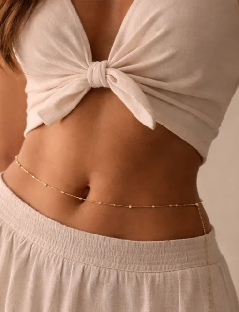 Gold waist chain with small bead links across the hips and belly