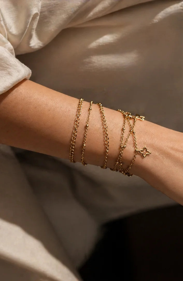 Gold-plated charm bracelets with star accents and multiple chain layers