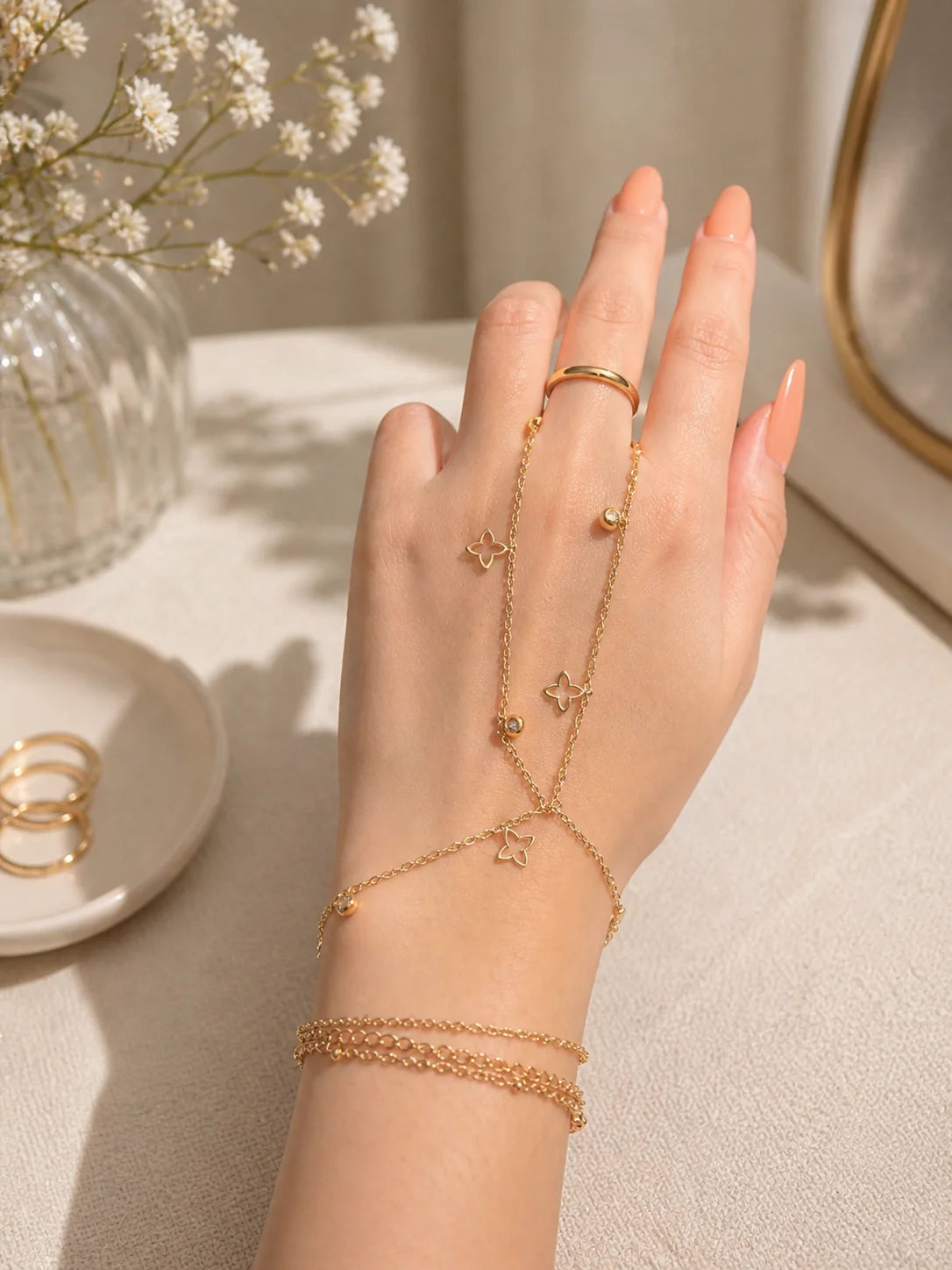 Gold-plated layered charm jewelry set with star motifs on hand