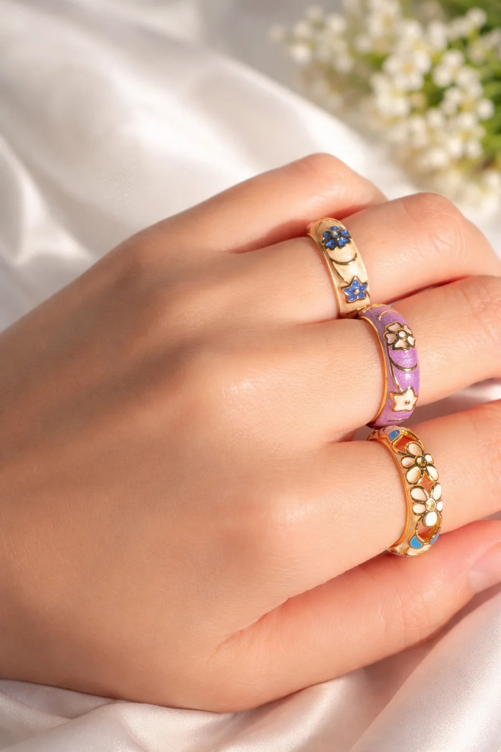 Purple enamel cuff ring with gold-tone flowers; worn on finger
