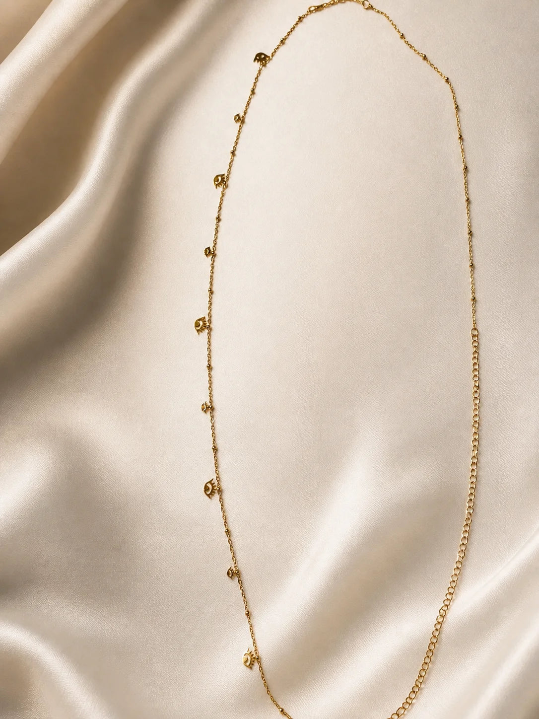 Gold-plated chain necklace with small charm drops along the length
