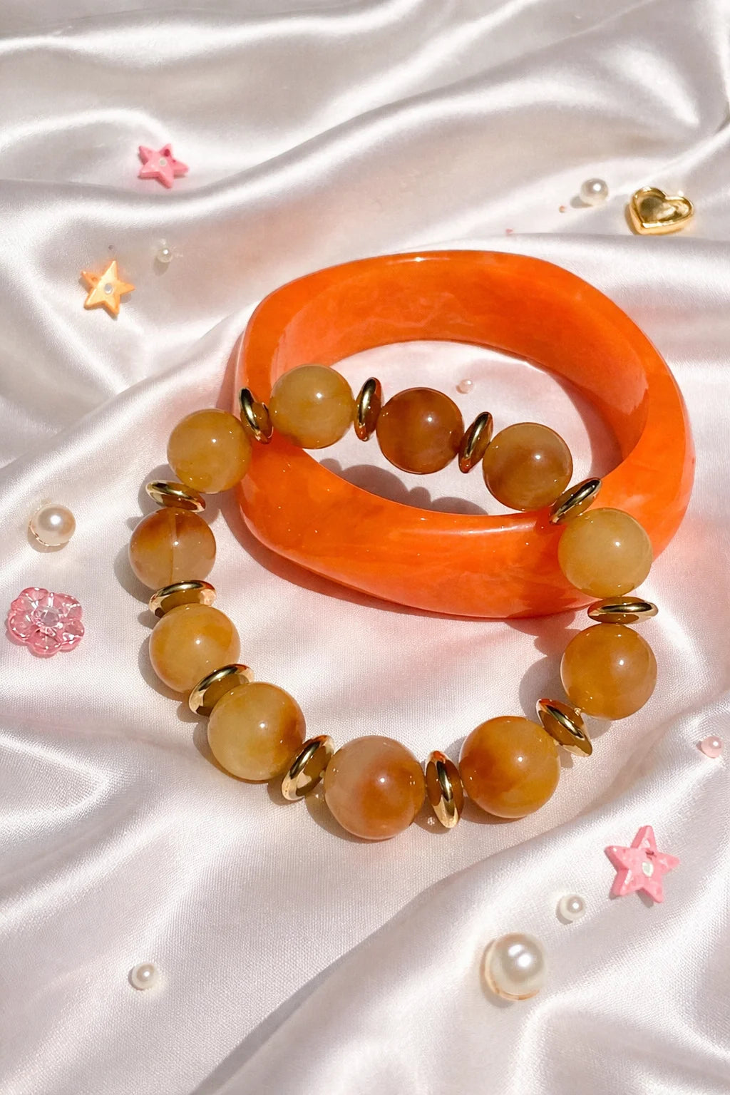 Orange resin bangle with amber beaded bracelets, gold-tone accents