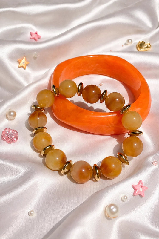 Orange resin bangle and amber beaded bracelet set with gold-tone accents and stretchy fit