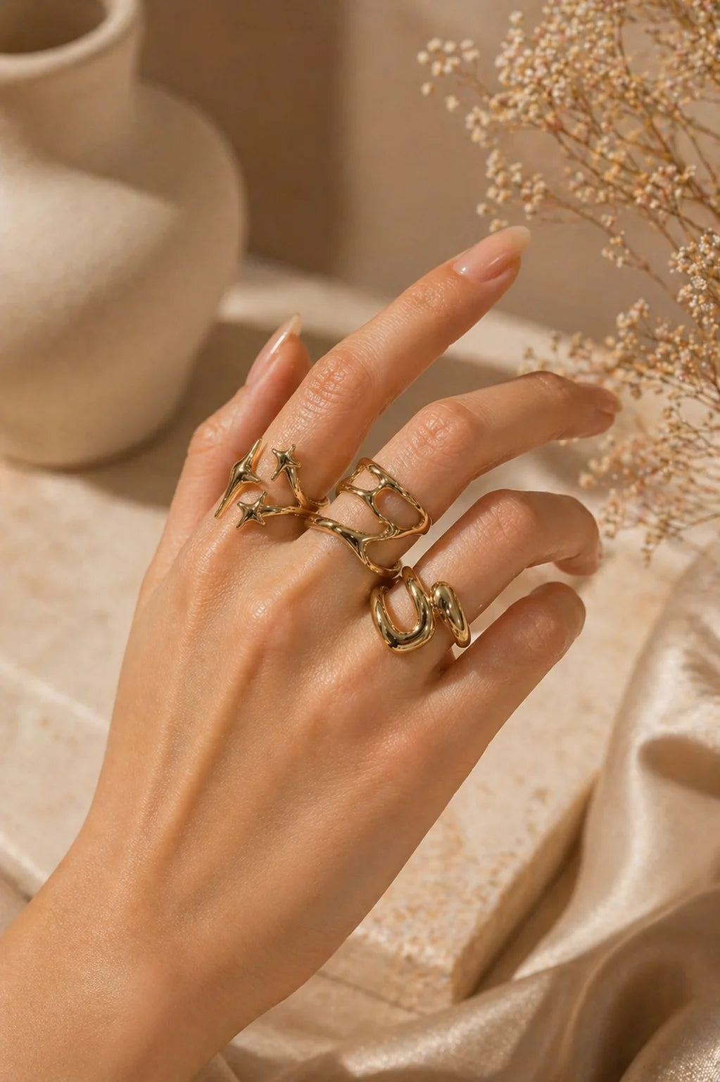 Gold tone knuckle ring set with star detail and linked bands on fingers
