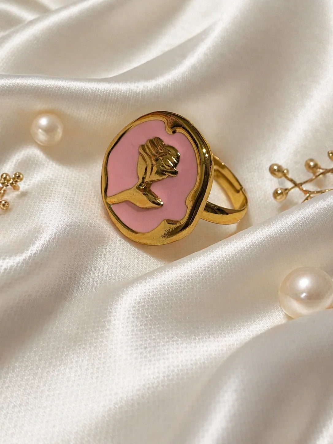 Gold-tone ring with rose-pink cameo center and engraved bird profile