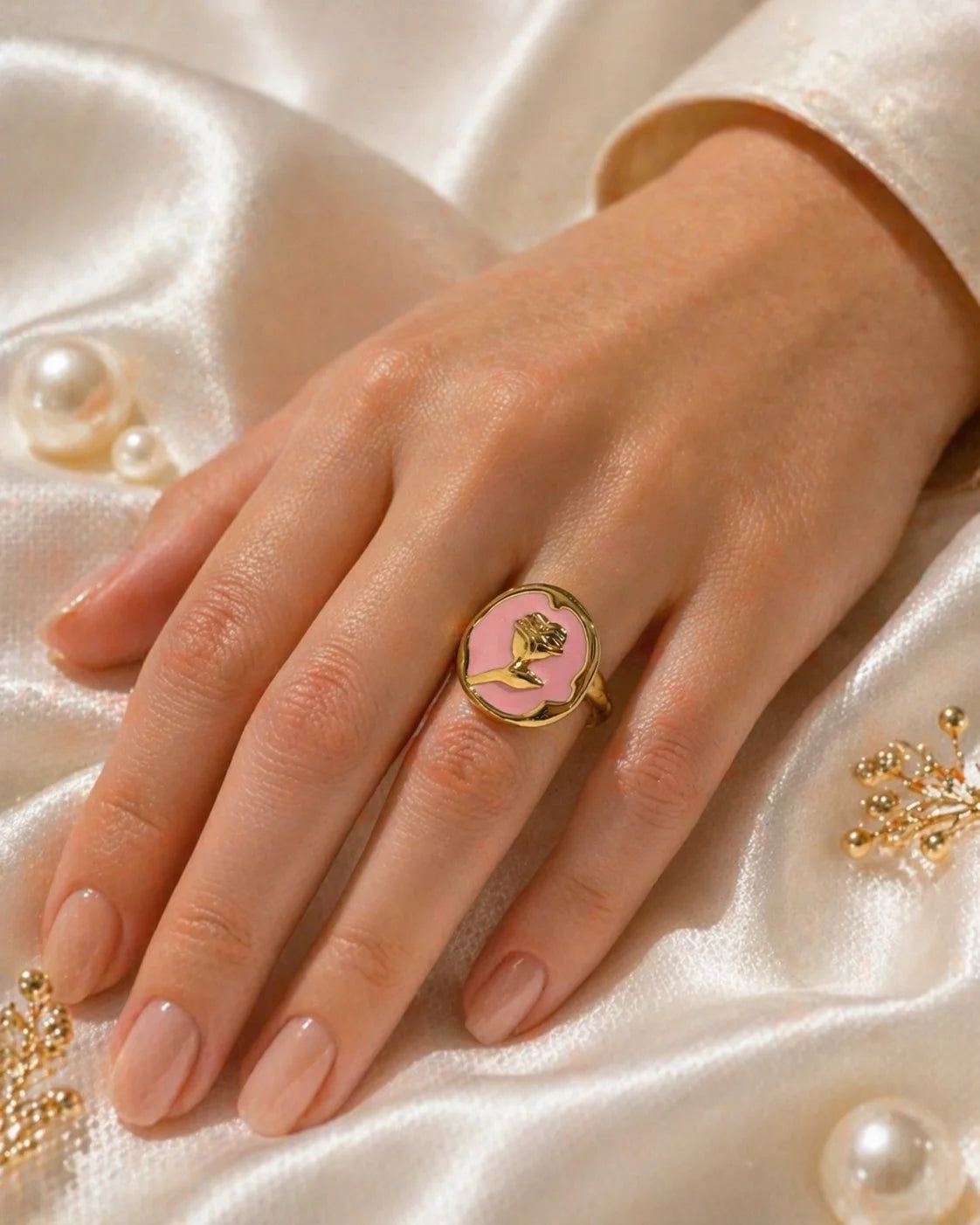 Rose-pink cameo ring on hand with gold-tone band