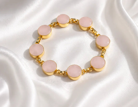 Gold bracelet with pink round stone discs on a linked chain