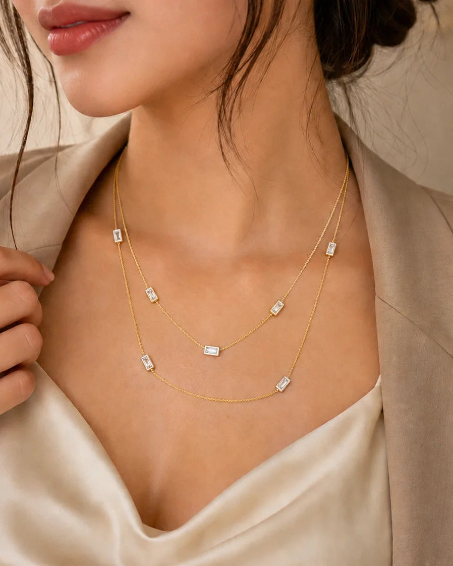 Gold layered necklace with multiple small square pendants on thin chain