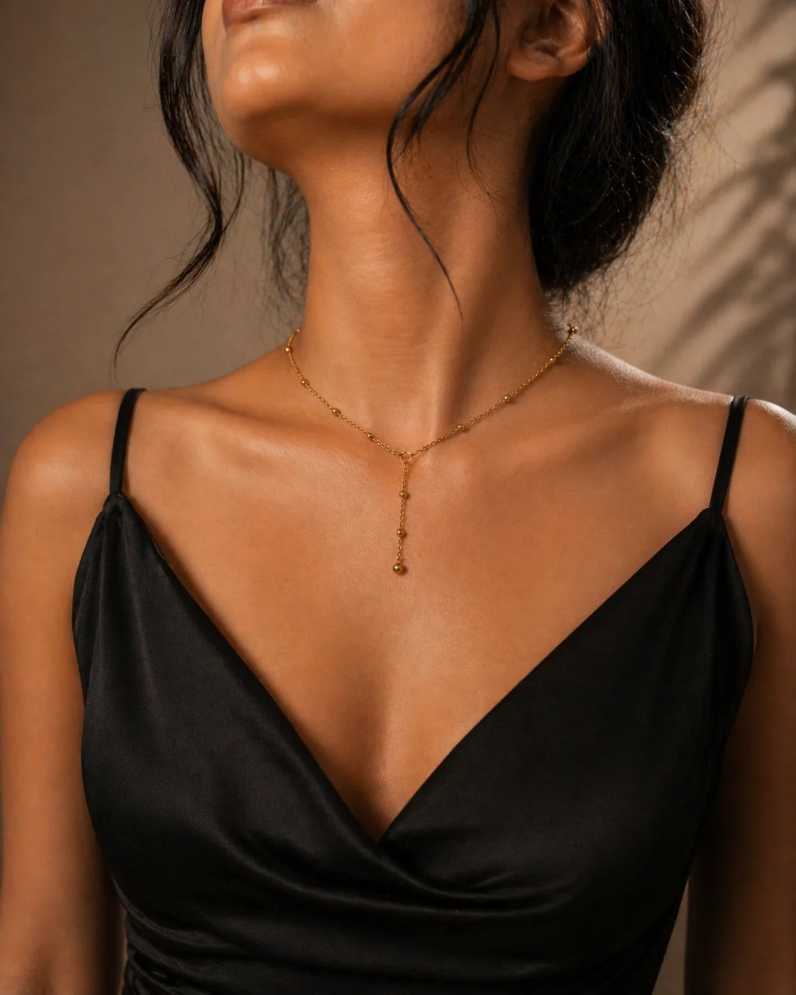 Backdrop chain necklace with gold bead drape and teardrop pendant at the front
